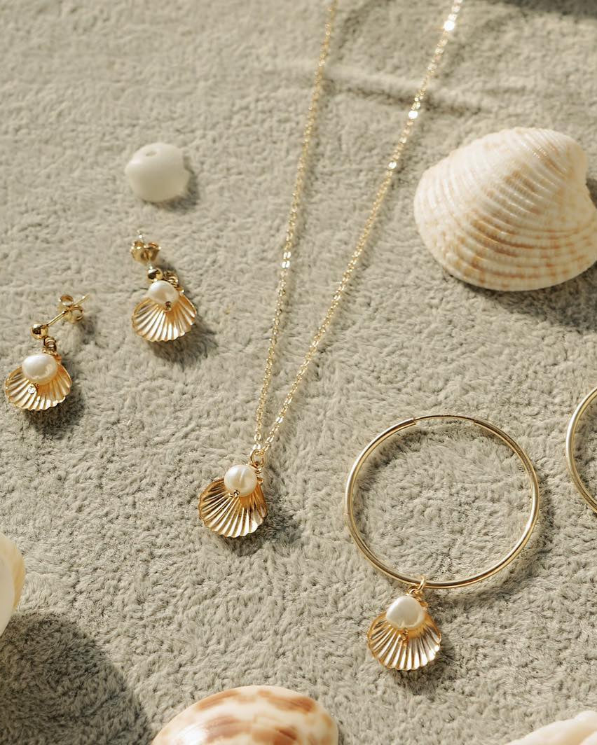 Belle Necklace by KOZAKH. A 16 to 18 inch adjustable length necklace in 14K Gold Filled, featuring a 5mm flat irregular Pearl and a Shell charm.