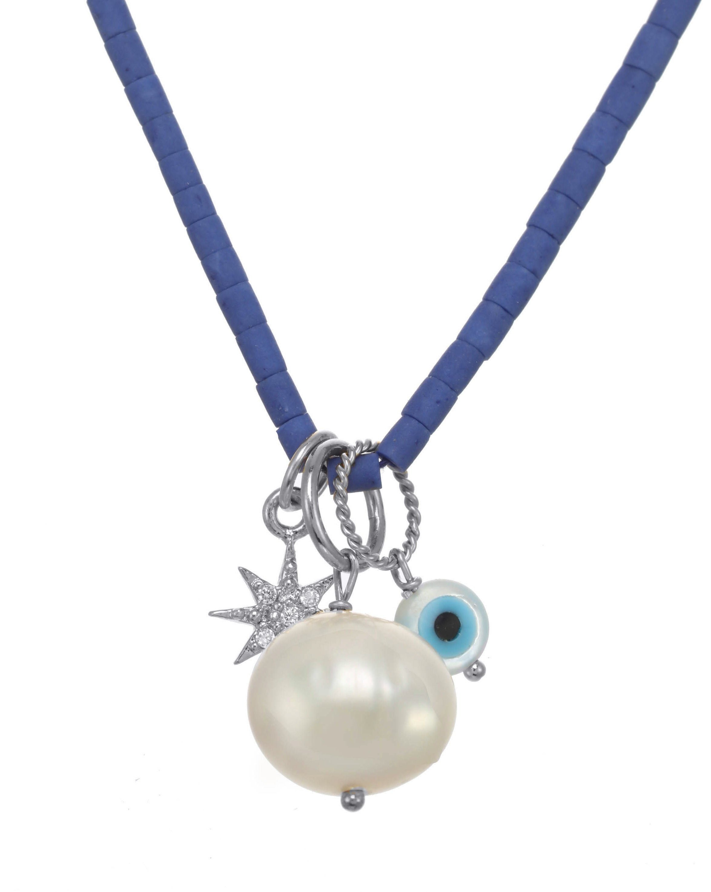 Brook Dark Blue Necklace by KOZAKH. A 13 to 16 inch adjustable length colored Afghan Beads strand necklace in Sterling Silver, featuring a hand carved Mother of Pearl evil eye charm, a round Freshwater Pearl, and a Cubic Zirconia encrusted star charm.