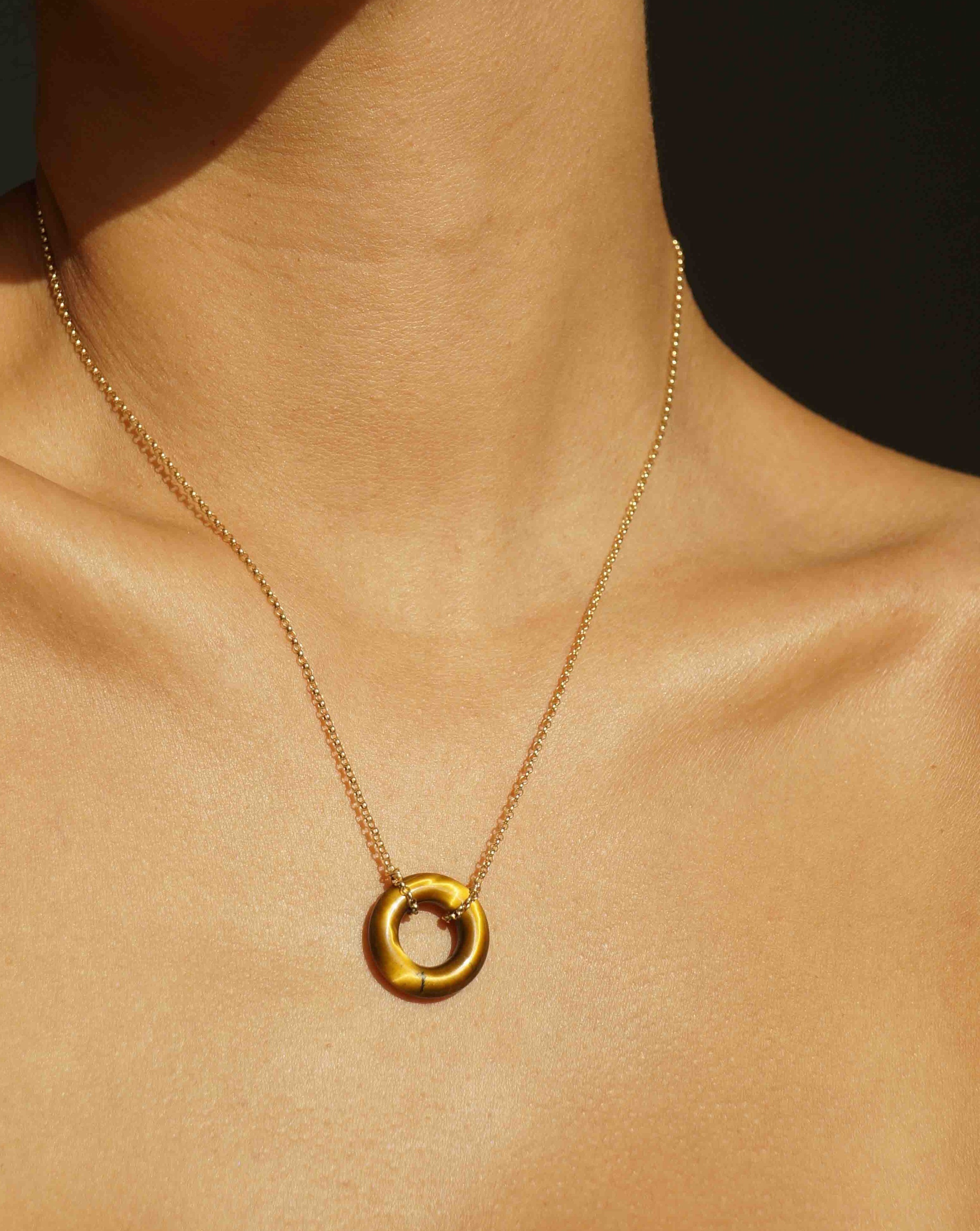 Cerceau Necklace by KOZAKH. A 17 inch long necklace in 14K Gold Filled, featuring a doughnut shape Tiger's Eye gemstone.