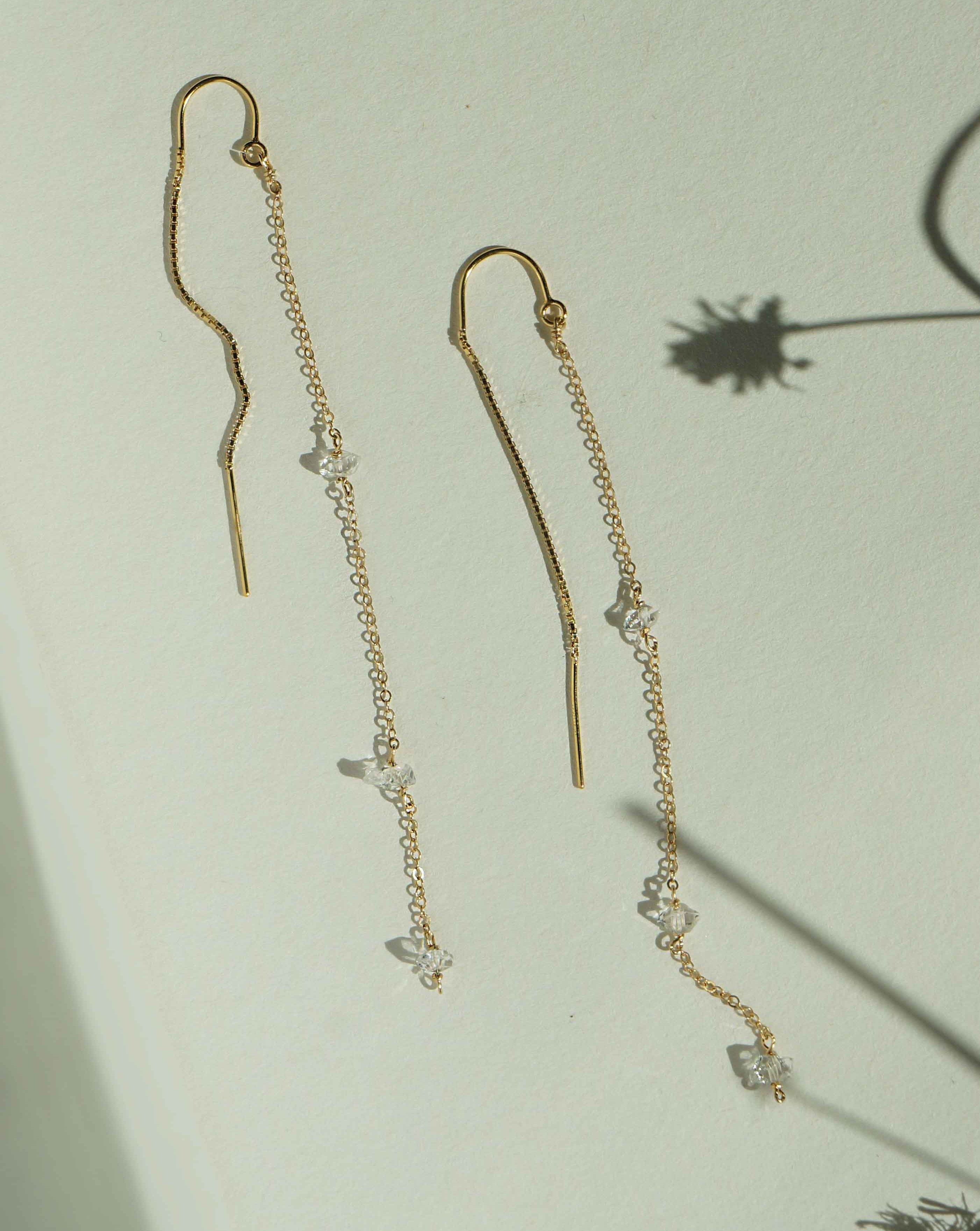 Chatoyant Threader Earrings by KOZAKH. 2 1/2 inch drop threader earrings in 14K Gold Filled, featuring Herkimer Diamonds.