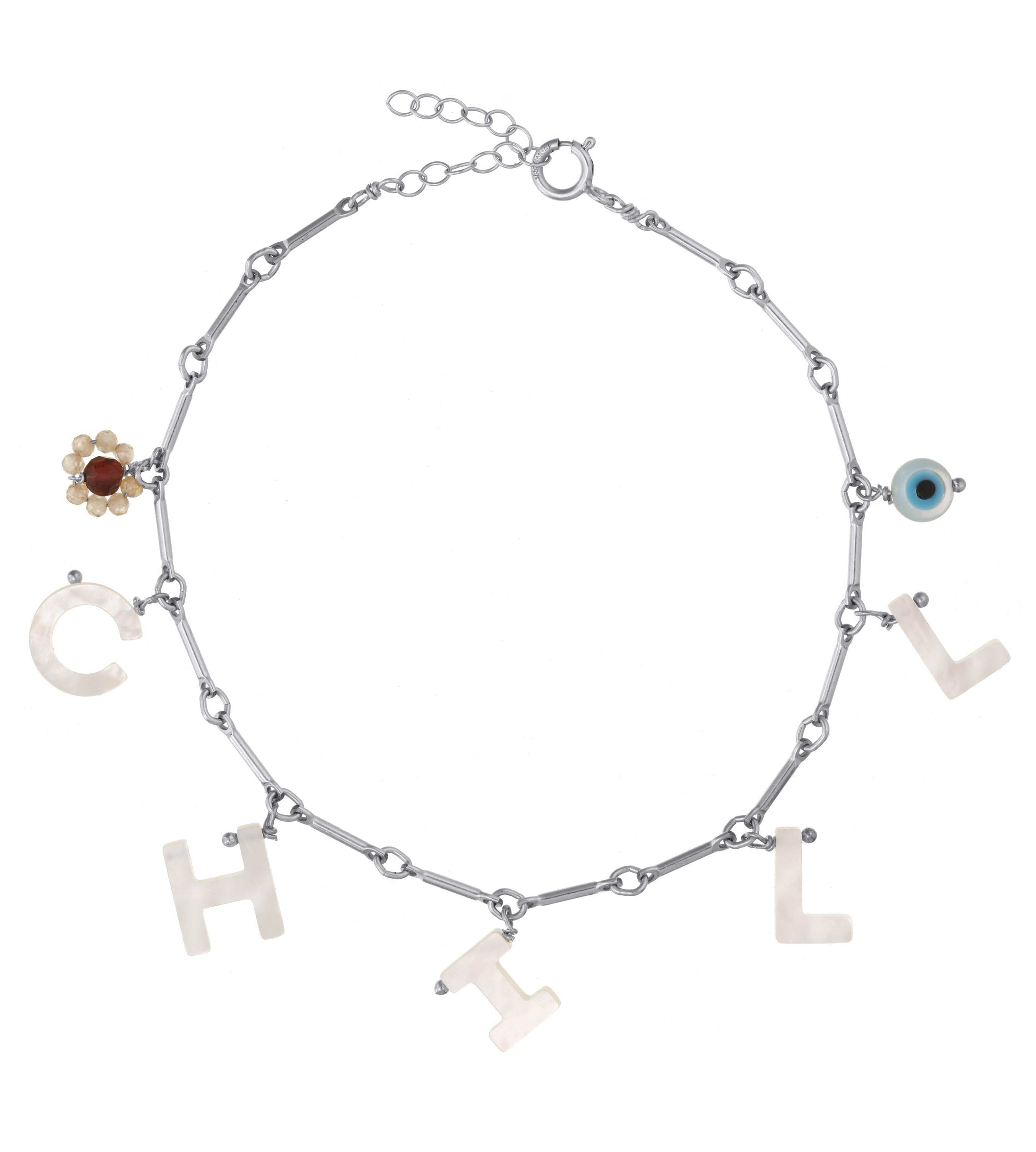 Shore Bracelet by KOZAKH. A 6 to 7 inch adjustable length bracelet, crafted in Sterling Silver, featuring a hand carved Mother of Pearl Evil Eye, raw Ruby and Imperial Topaz gemstone flower, and a customizable word made out of hand carved Mother of Pearl letters. 