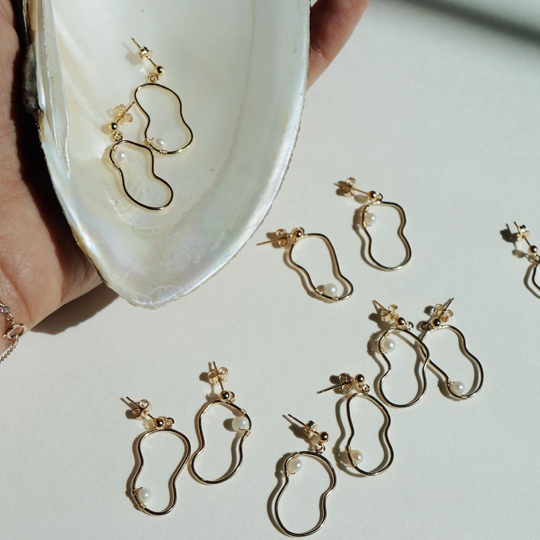 Darroch Earrings by KOZAKH. Dangling earrings crafted in 14K Gold Filled, featuring a 5mm to 6mm white Potato Pearl in a charm made with free hand wire wrapping.