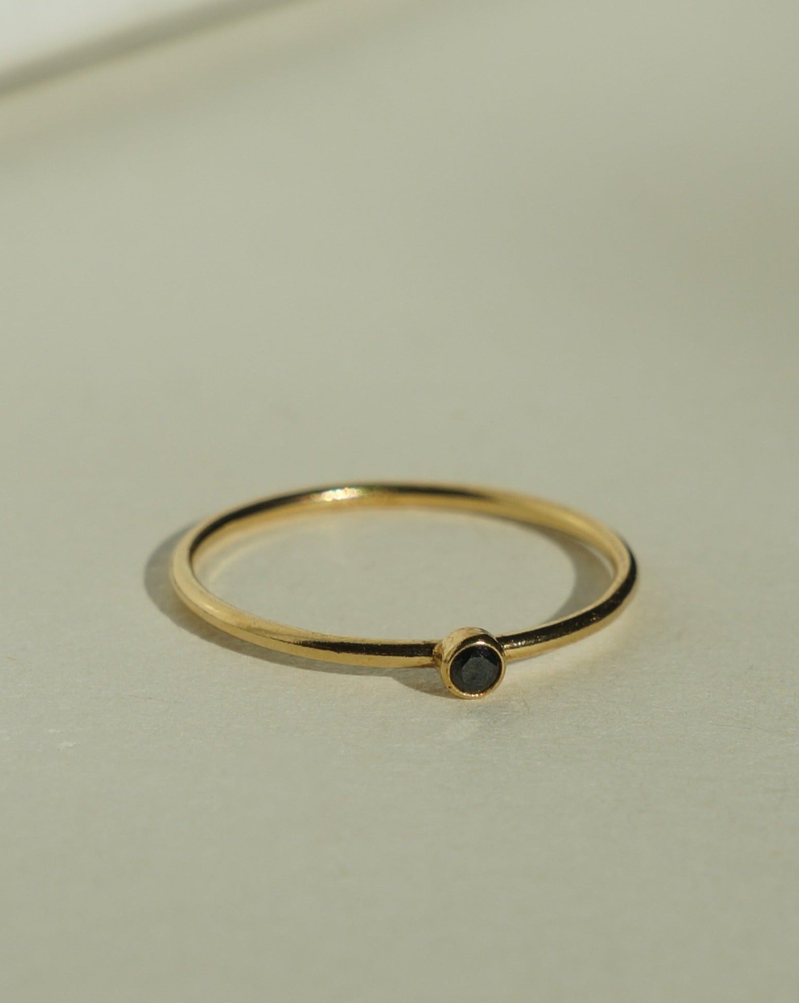 Dia Black Ring by KOZAKH. A 1mm thick ring, crafted in 14K Gold Filled, featuring a 2mm black Spinel bezel.