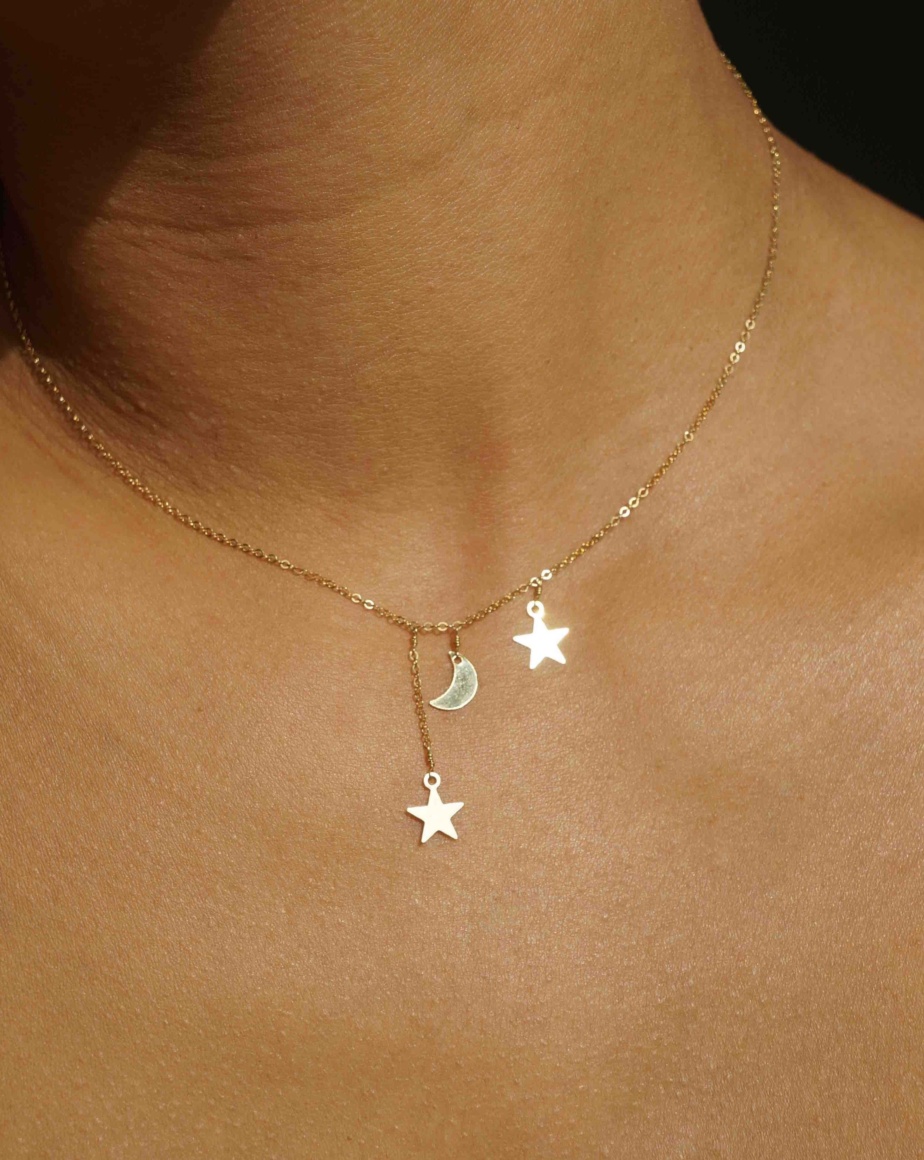 Filante Necklace by KOZAKH. A 16 to 18 inch adjustable length necklace in 14K Gold Filled, featuring moon and star charms with 1 star charm drop of about 0.5 inch. 