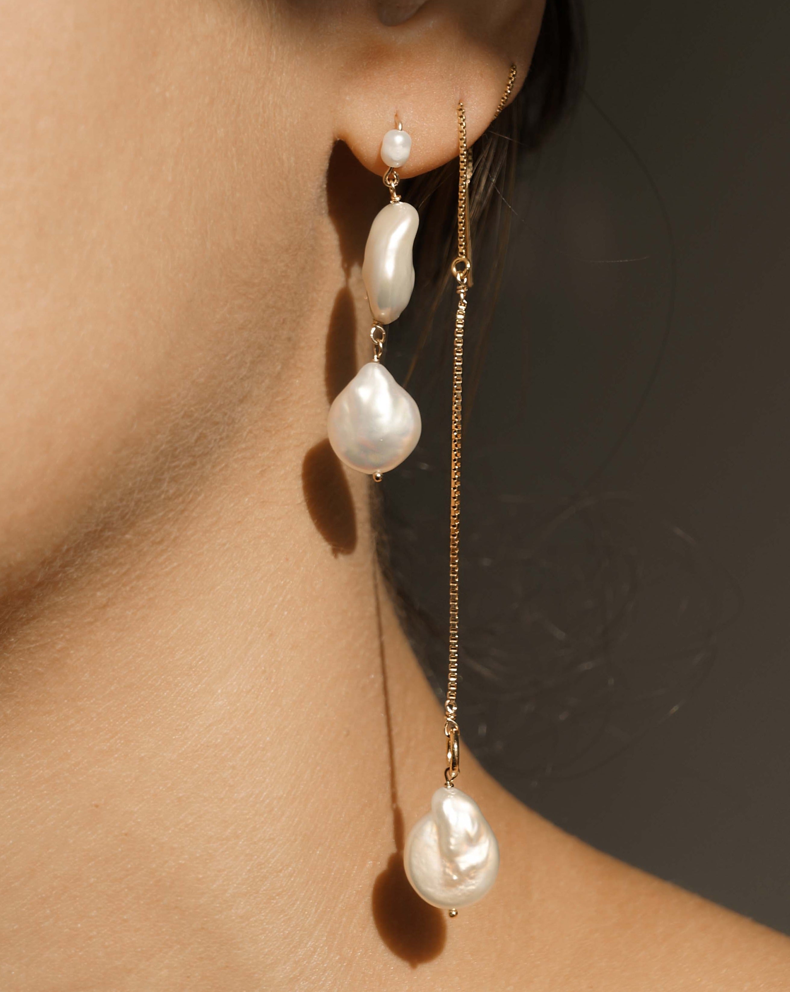 Genesis Threaders by KOZAKH. Threader style earrings with drop length of 2 inches on both sides, crafted in 14K Gold Filled, featuring Baroque Pearls.