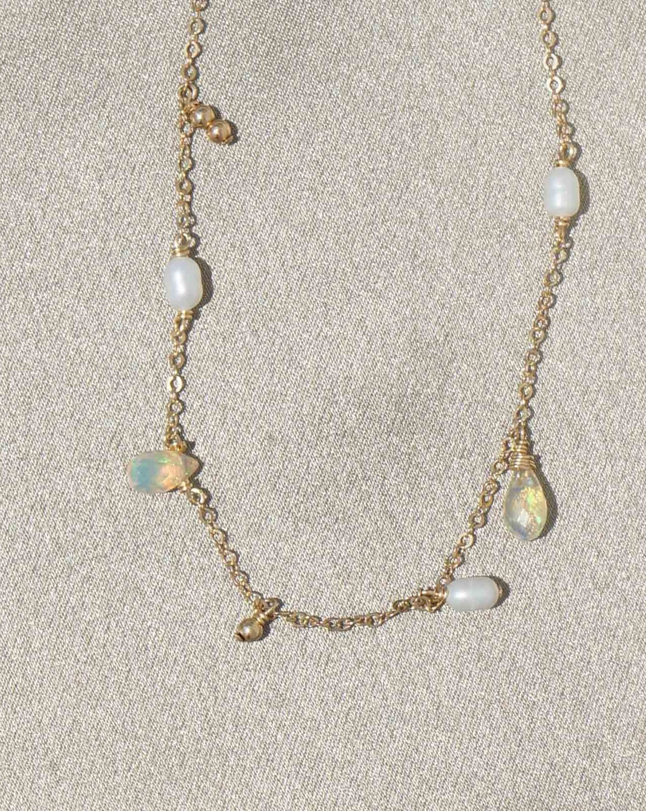 Genevieve Necklace by KOZAKH. A 16 to 18 inch adjustable length necklace in 14K Gold Filled, featuring 3-4mm white rice Pearls and 5-6mm faceted Ethiopian Opal droplets.