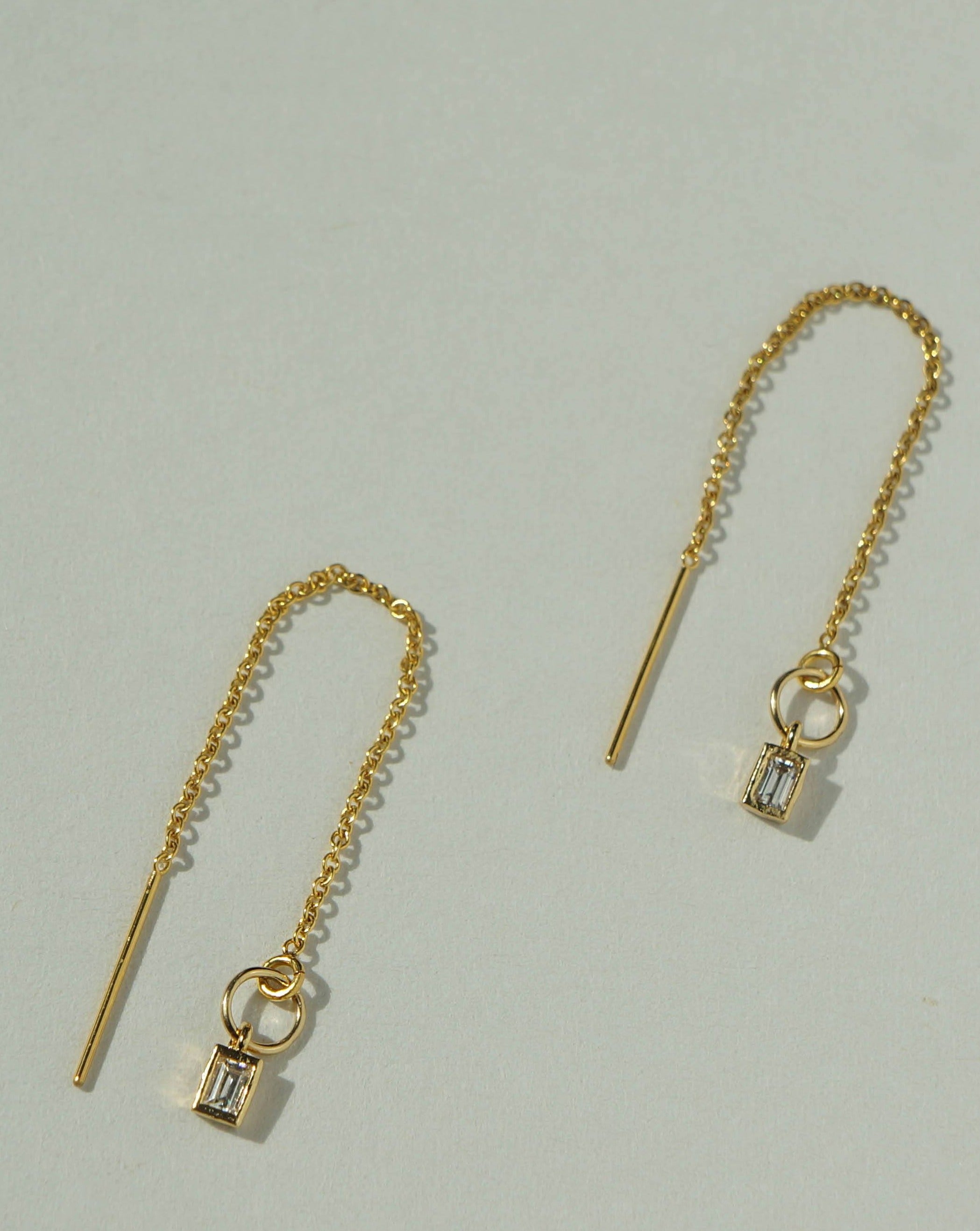 Grace Threaders by KOZAKH. Threader style earrings with drop length of 1 inch on both sides, crafted in 14K Gold Filled, featuring a square cut Cubic Zirconia.