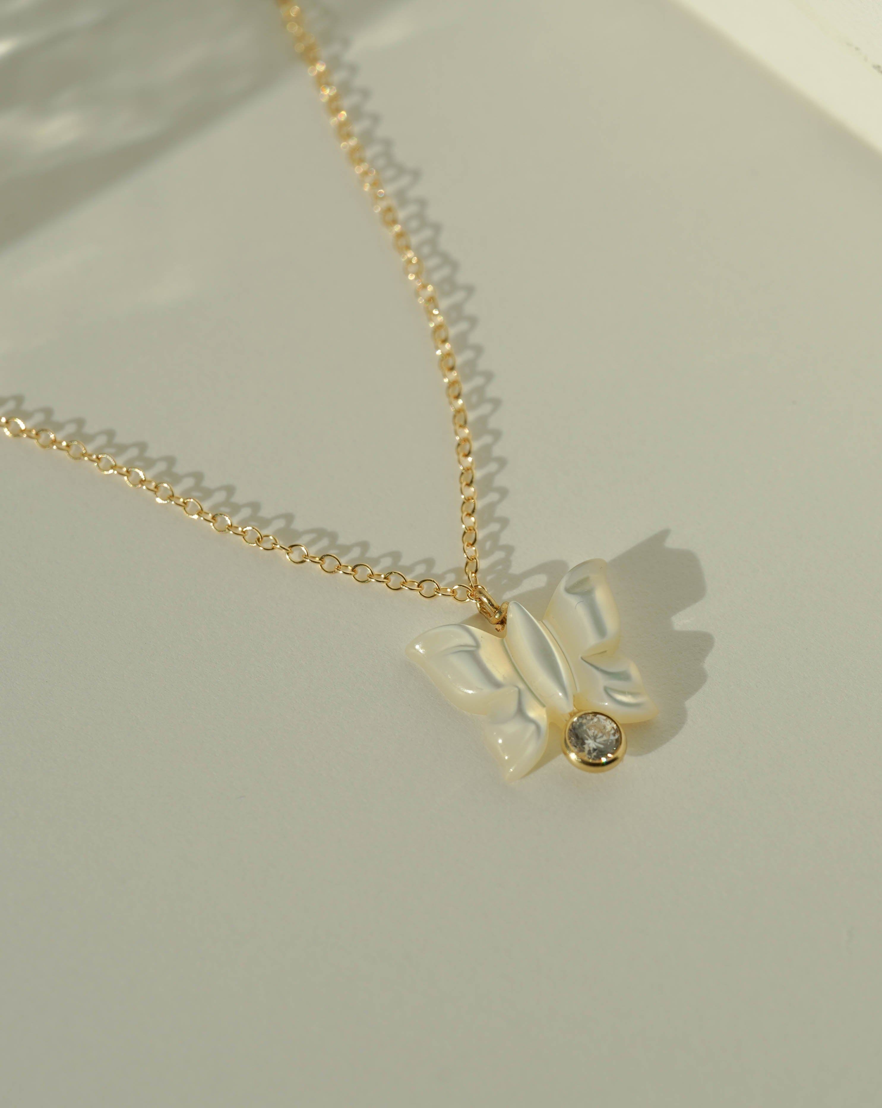 Halo Necklace by KOZAKH. A 16 to 18 inch adjustable length necklace in 14K Gold Filled, featuring a hand-carved Mother of Pearl butterfly charm and a 3mm Cubic Zirconia bezel.