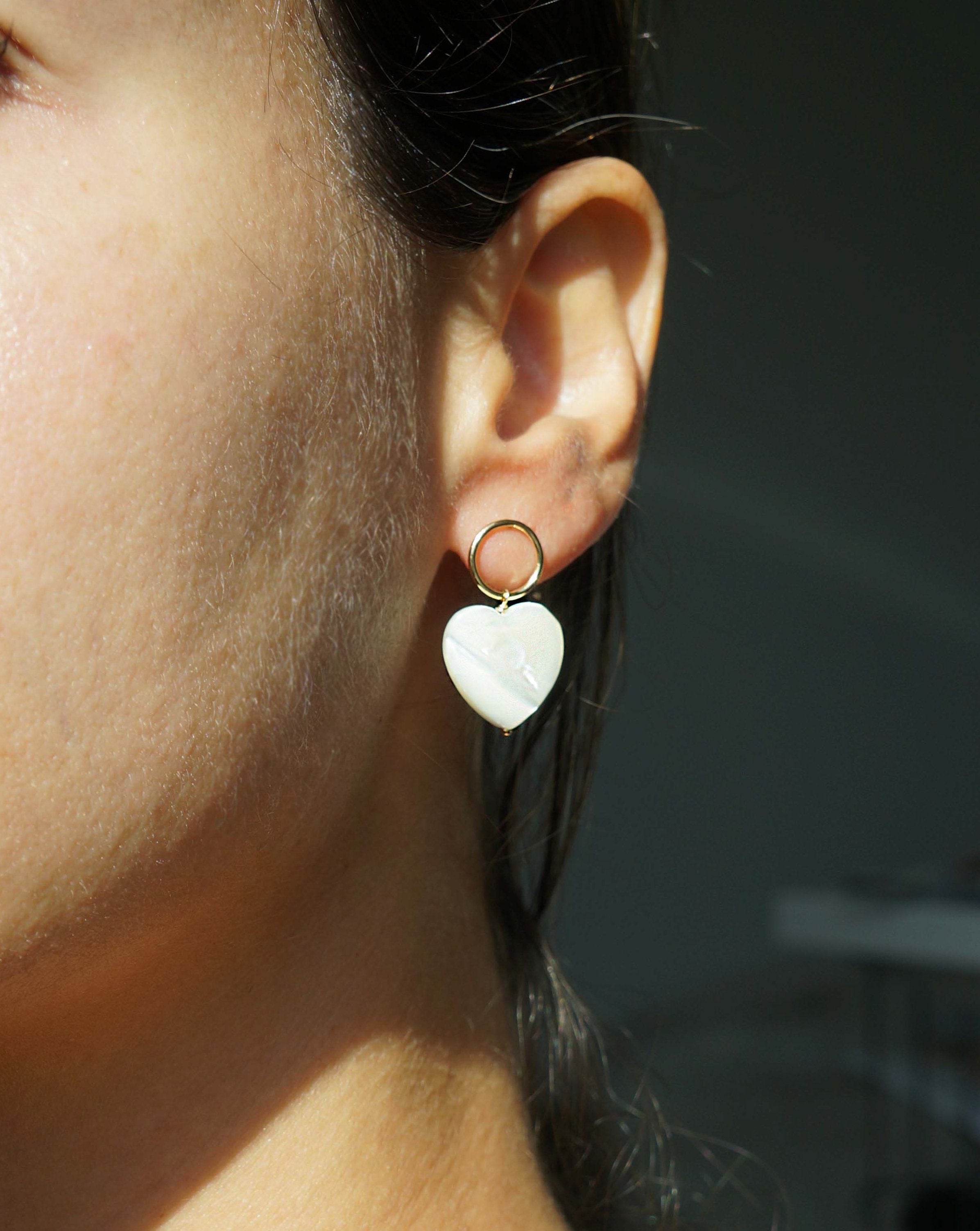 Heart Earrings by KOZAKH. Stud earrings, crafted in 14K Gold Filled, with hoop and hand carved faceted Mother of Pearl heart charm.