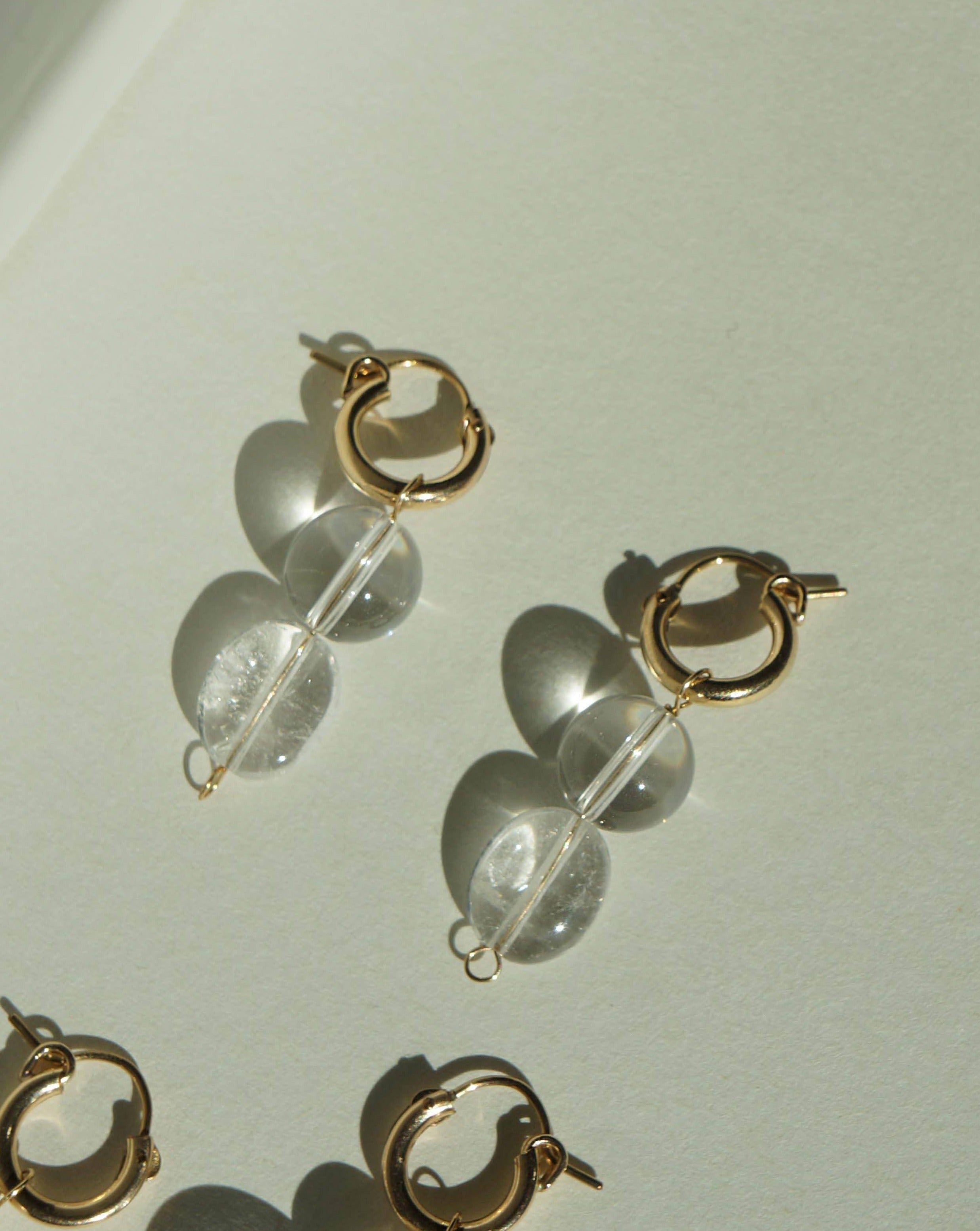 Lai Hoops Earrings by KOZAKH. 12mm snap closure hoop earrings, crafted in 14K Gold Filled, featuring Crystal Quartz.