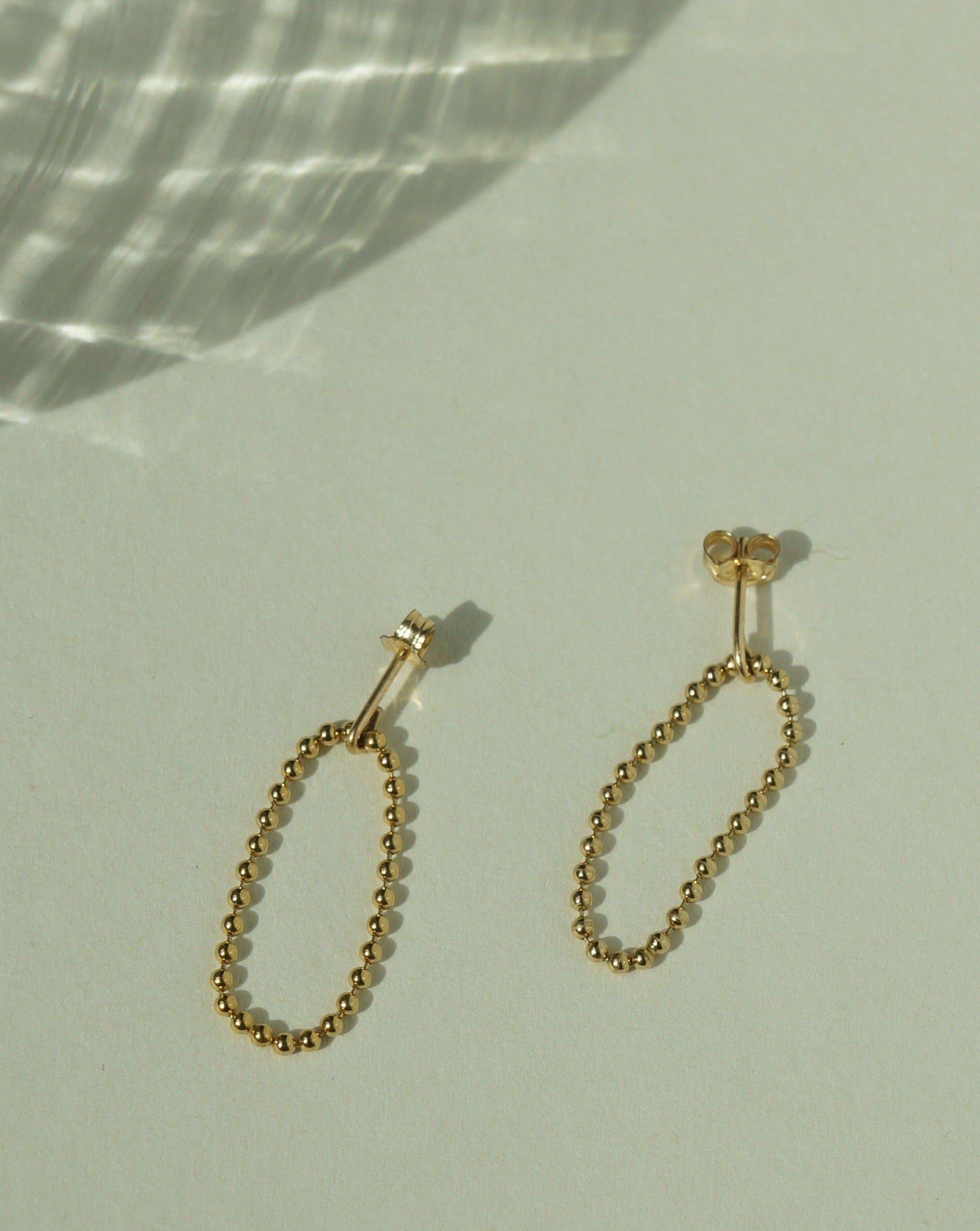 Lata Earrings by KOZAKH. 14K Gold Filled drop style stud earrings, with drop length of 1 inch, featuring linked gold balls.