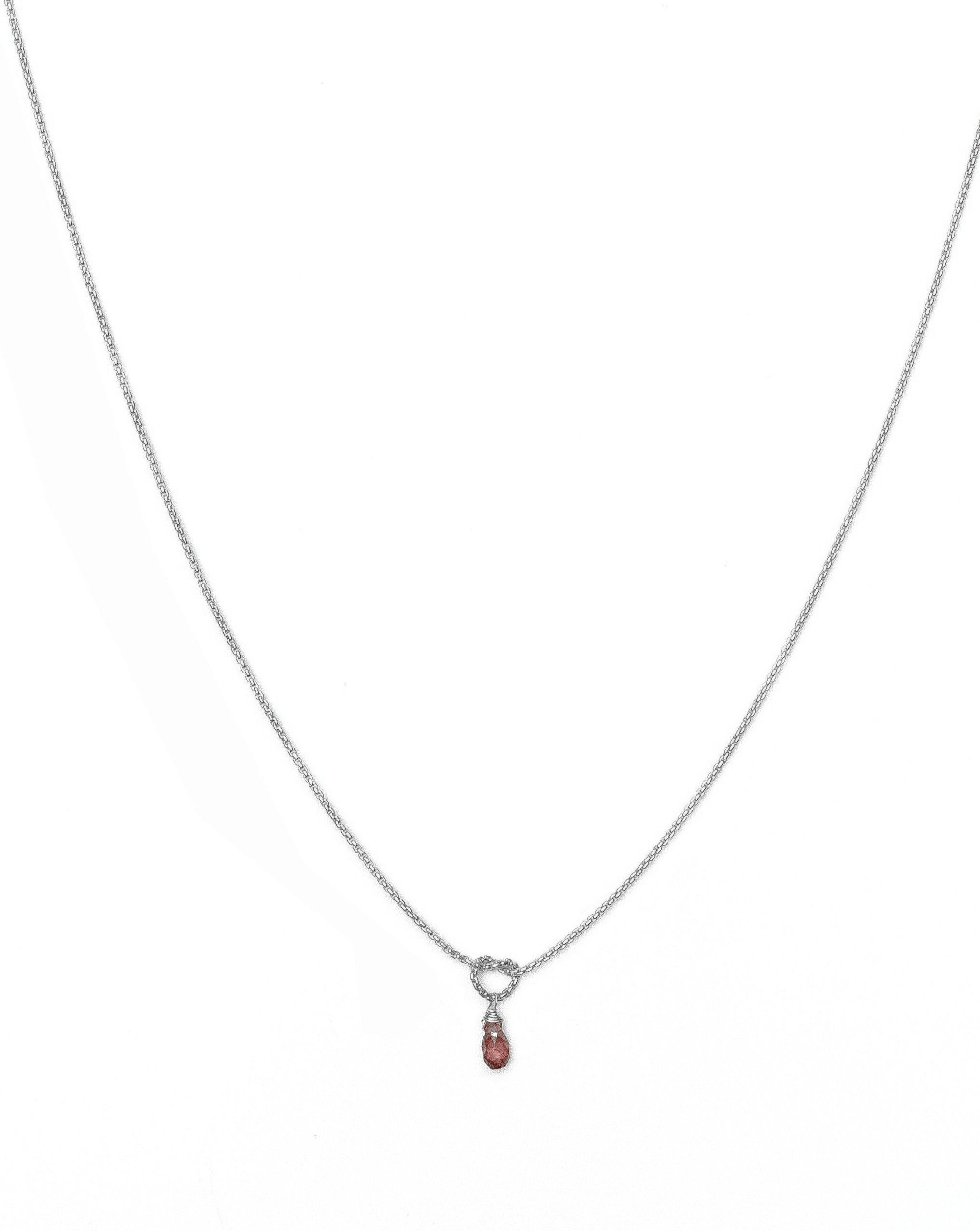 Love Knot Necklace by KOZAKH. A 16 to 18 inch adjustable length necklace, crafted in Sterling Silver, featuring a knot and a faceted Burgundy Sapphire droplet.