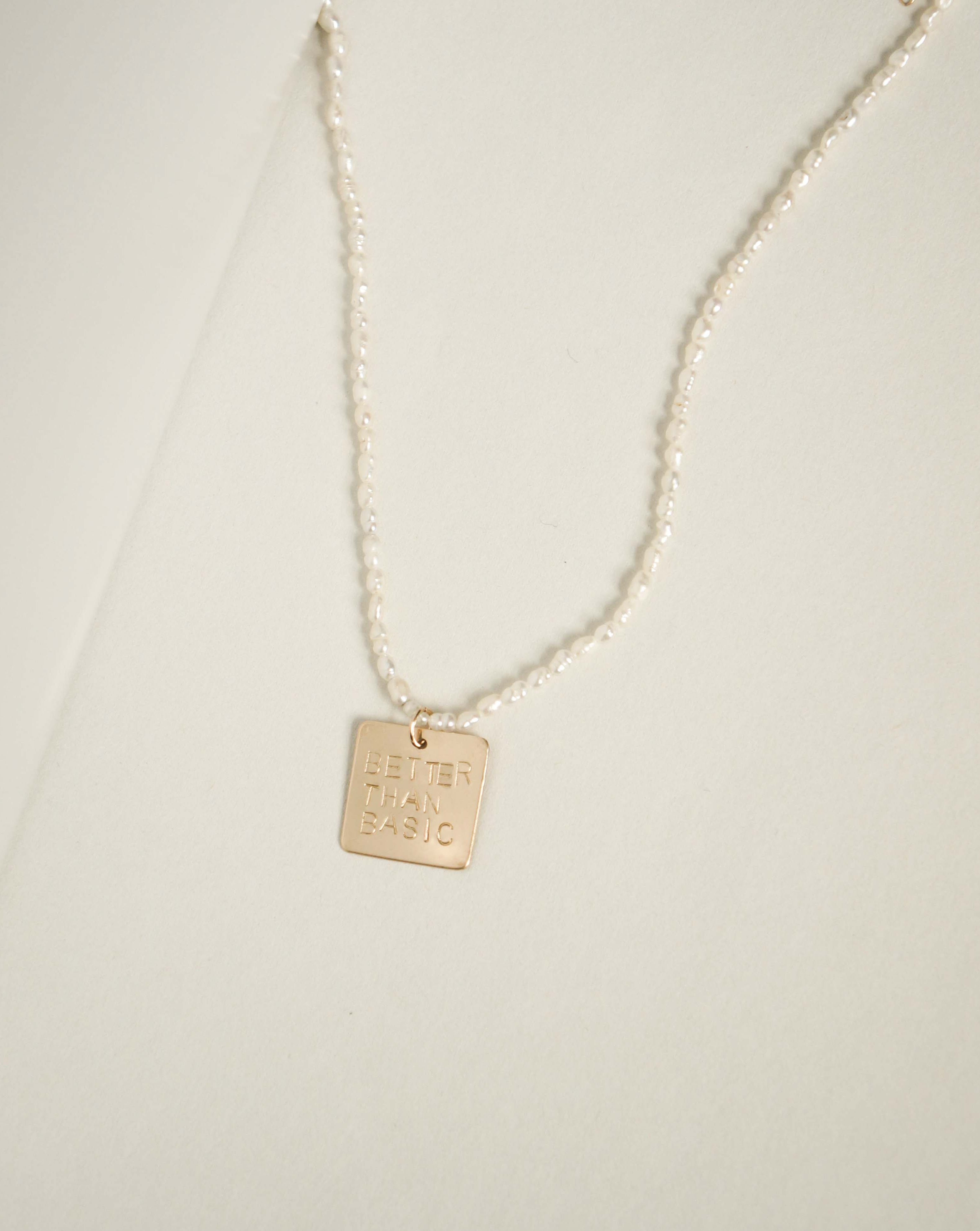 Magic Necklace by KOZAKH. A 16 to 18 inch adjustable length necklace with Freshwater rice Pearls strand, crafted in 14K Gold Filled, featuring a square pendant with an engraved quote.