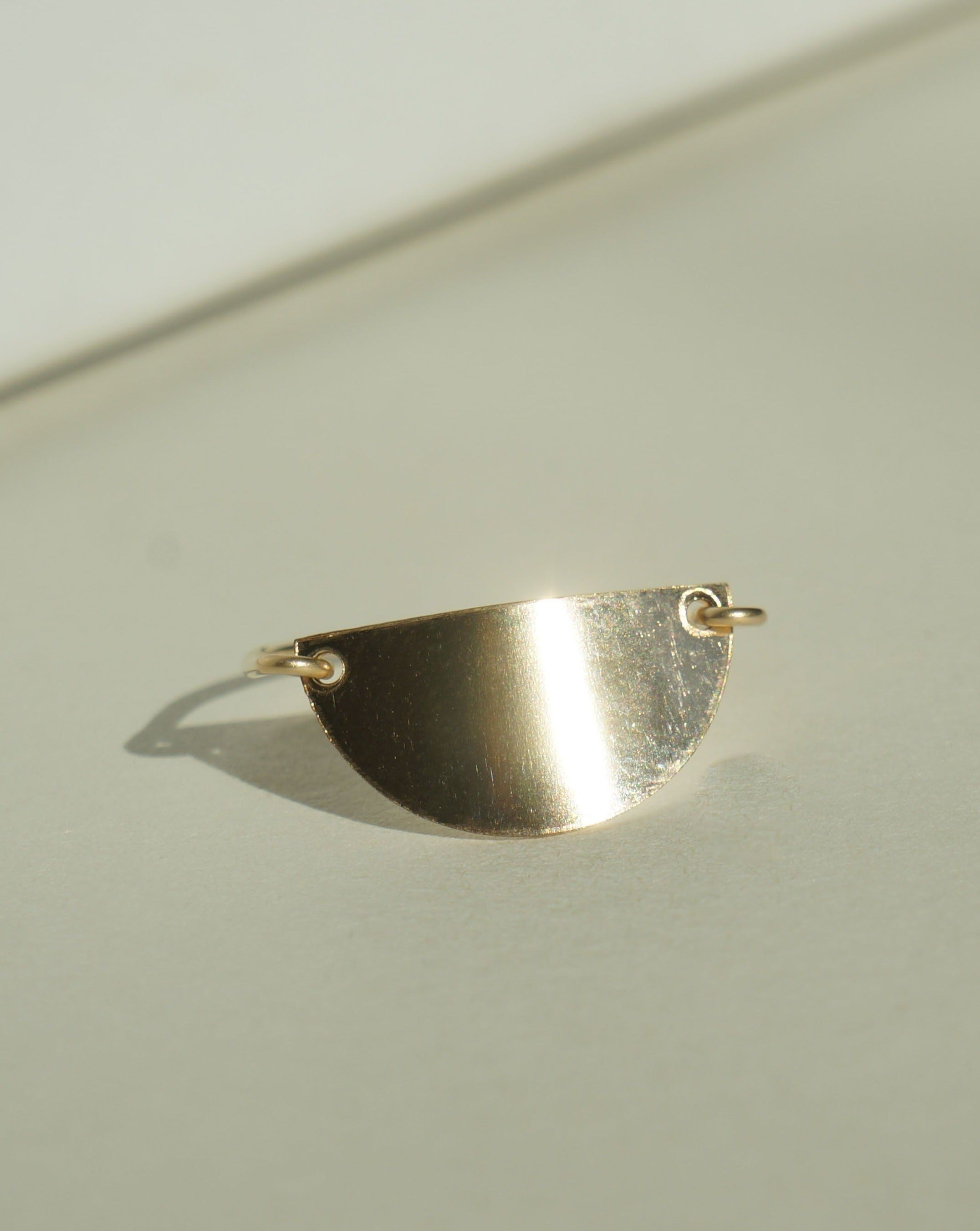 Meda Ring by KOZAKH. A 1mm band crafted in 14K Gold Filled, featuring a half moon shaped flat metal.