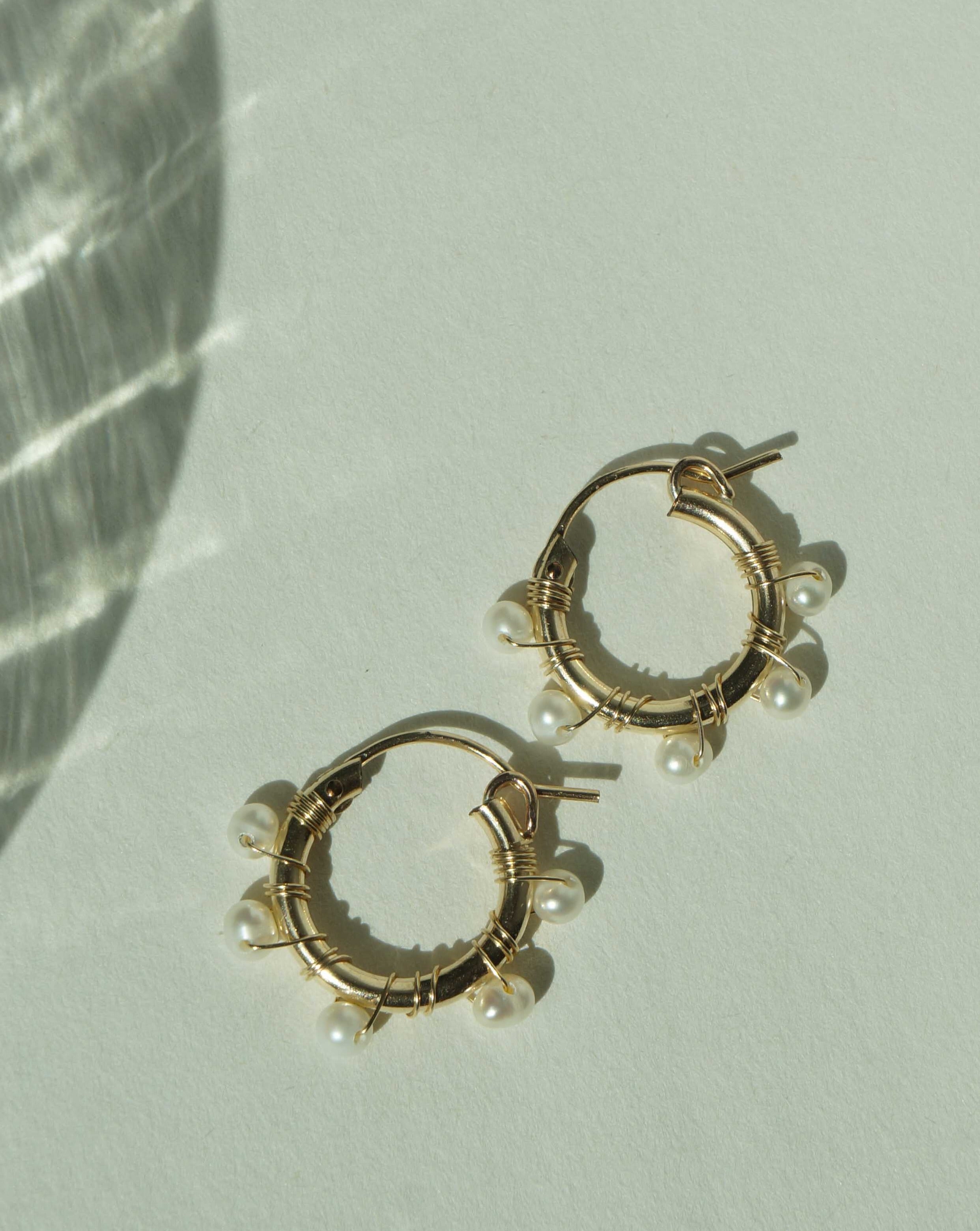 Natasha Hoop Earrings by KOZAKH. 12mm snap closure hoop earrings in 14K Gold Filled, featuring 7mm white potato Pearls.