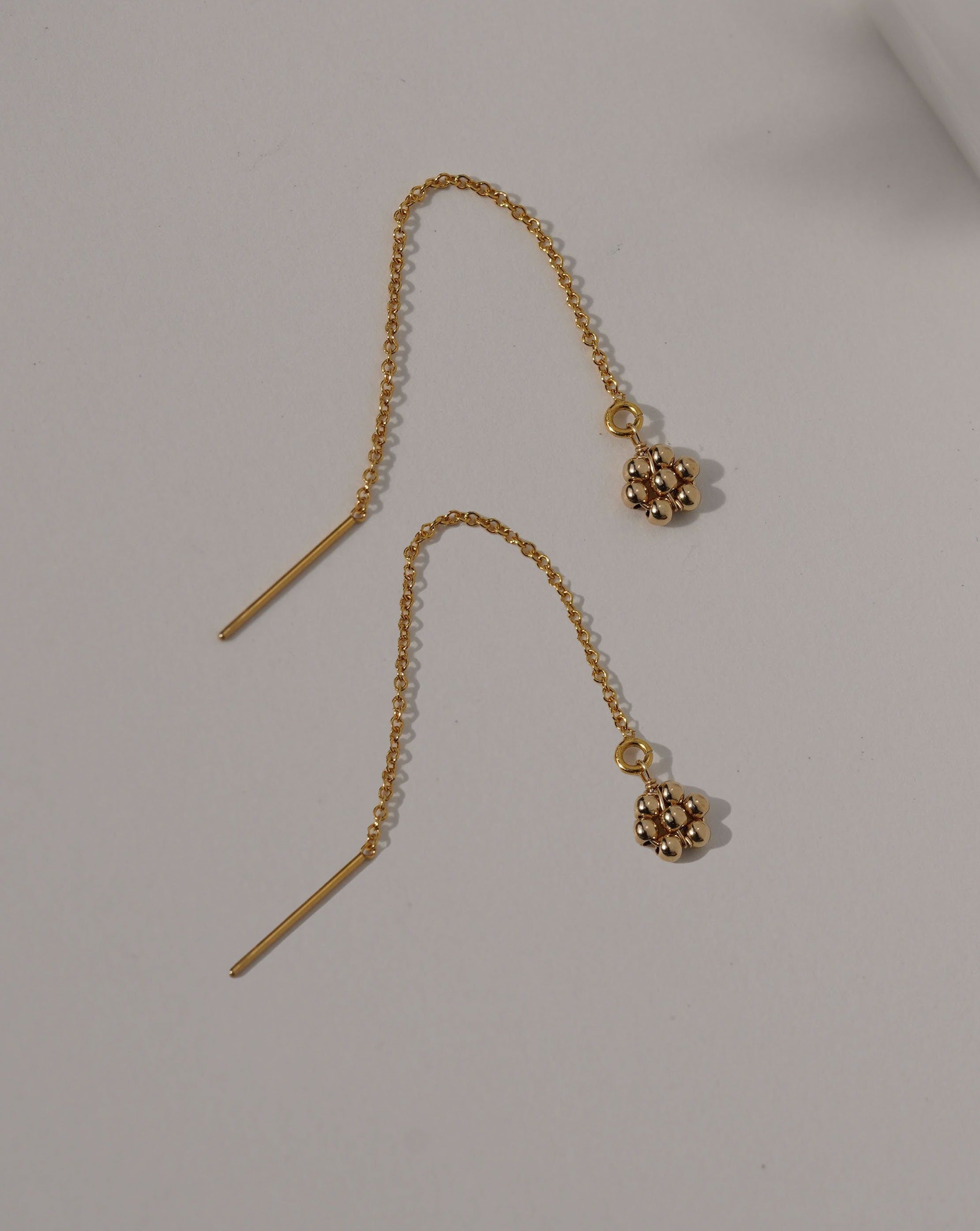 Noor Threader Earrings by KOZAKH. Threader style earrings, crafted in 14K Gold Filled, featuring handmade beaded daisy charms.