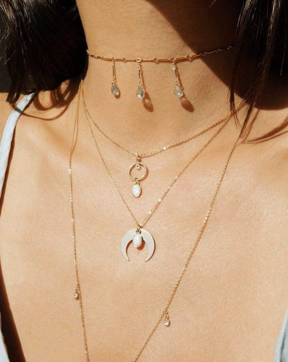 Opal Moon Necklace by KOZAKH. A 16 to 18 inch adjustable length necklace, crafted in 14K Gold Filled, featuring an oval Opal charm and a moon charm.