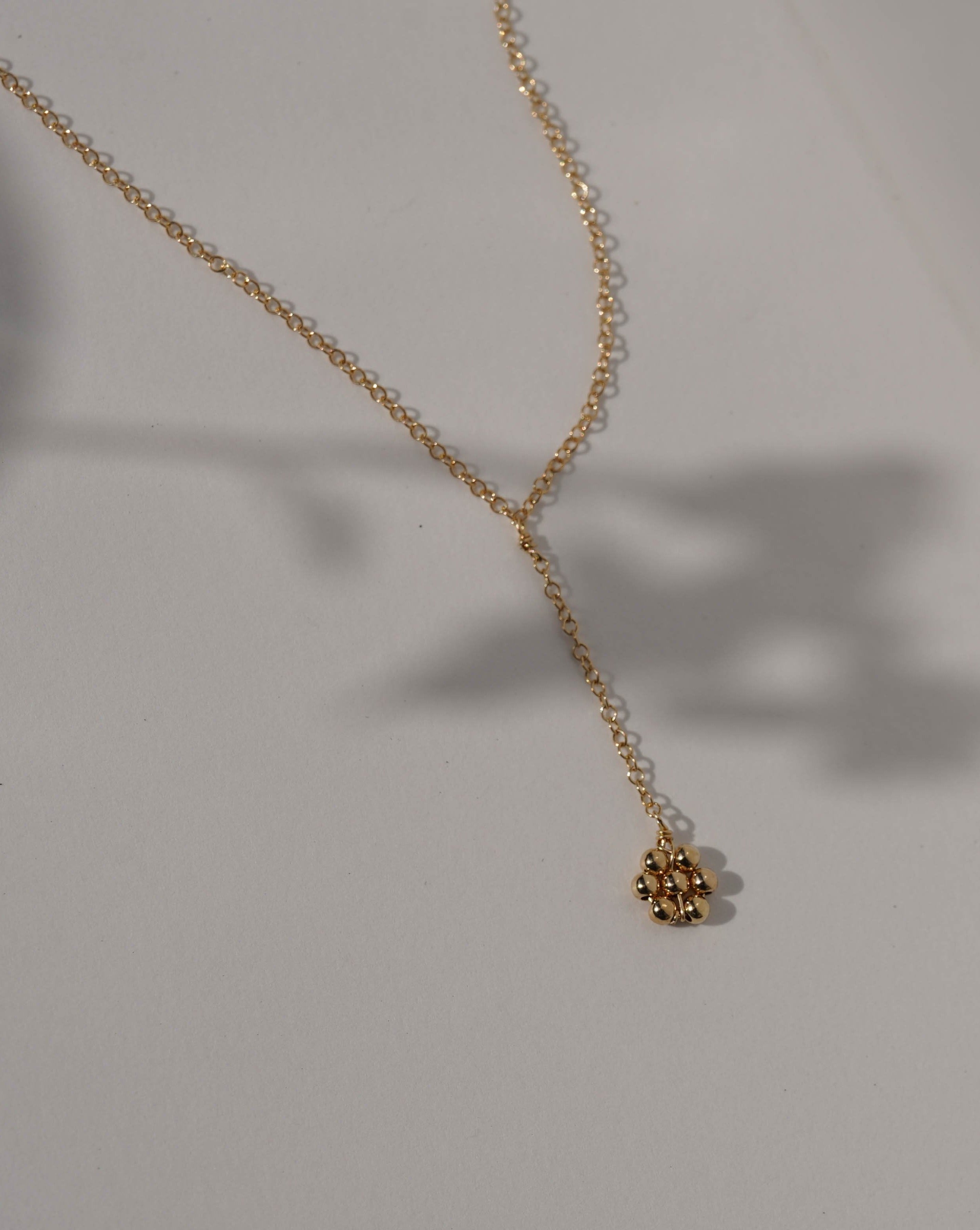 Paloma Necklace by KOZAKH. A 16 to 18 inch adjustable length, 3 inch drop lariat style necklace, crafted in 14K Gold Filled, featuring a handmade beaded daisy charm.
