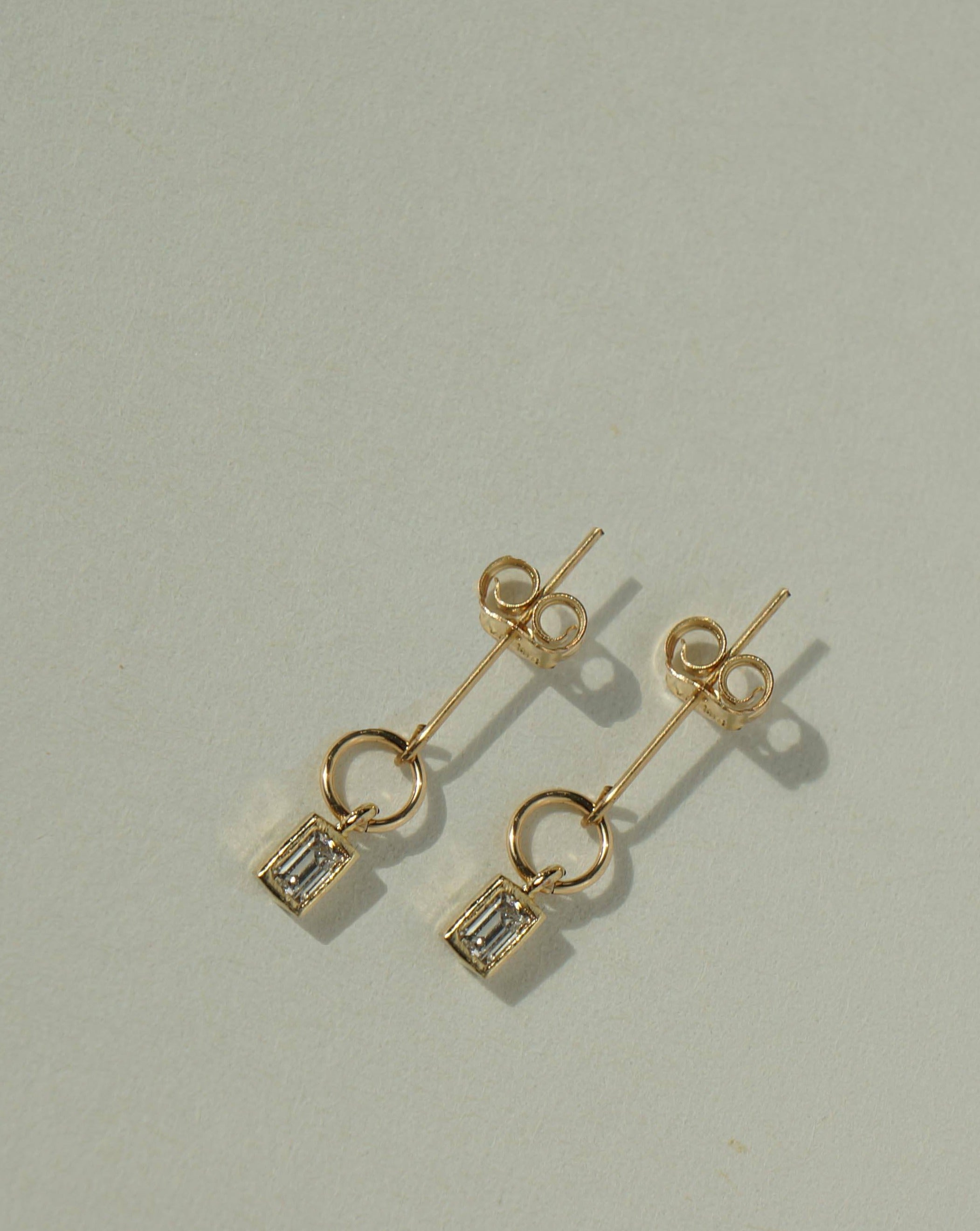 Penelope Earrings by KOZAKH. Stud earrings with mini dangle, crafted in 14K Gold Filled, featuring a faceted square cut Cubic Zirconia.