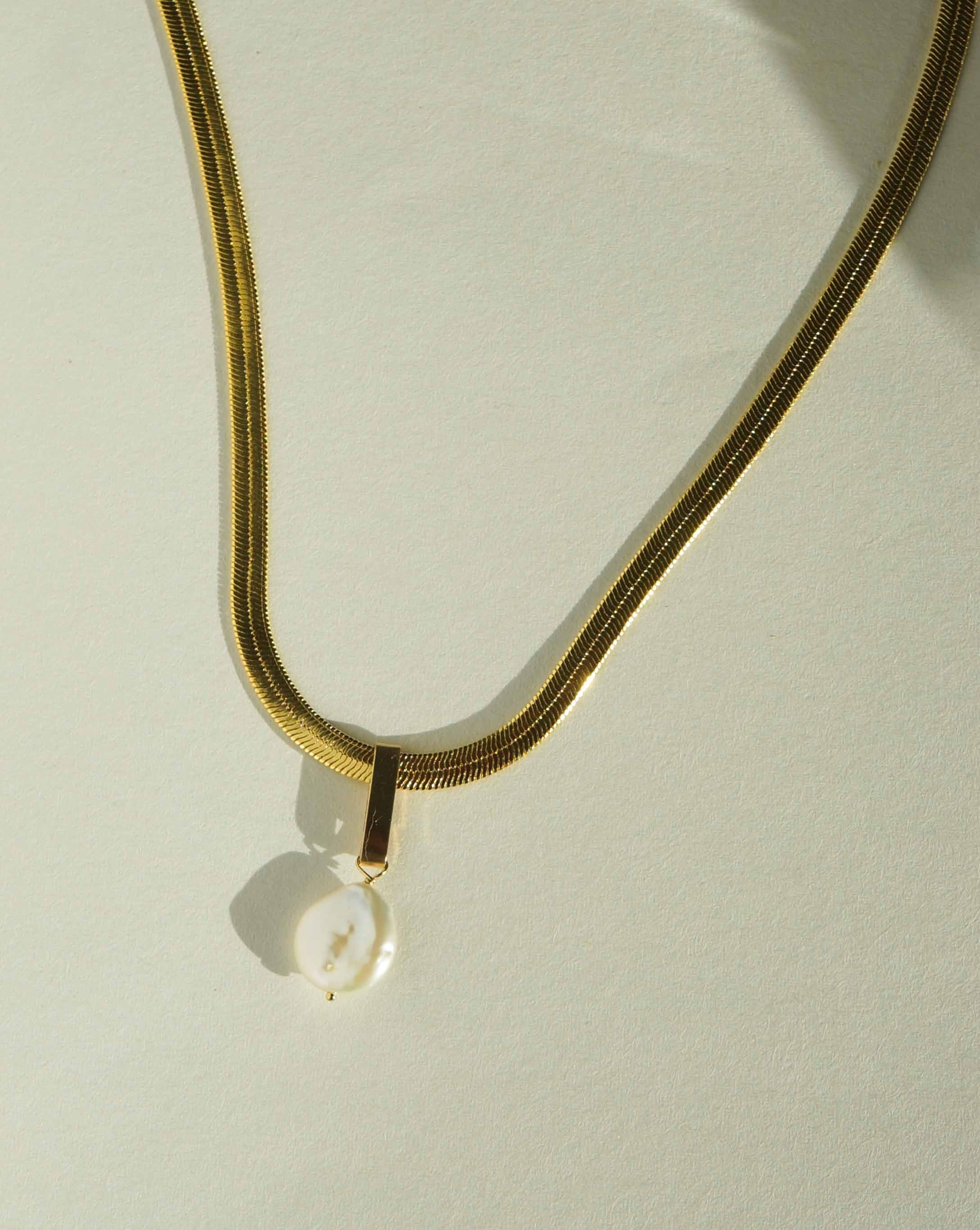 Sam Necklace by KOZAKH. A 16 inches long Herringbone chain necklace, crafted in 18K Gold bonded chain with anti-tarnish treatment, featuring a white tail coin Pearl.