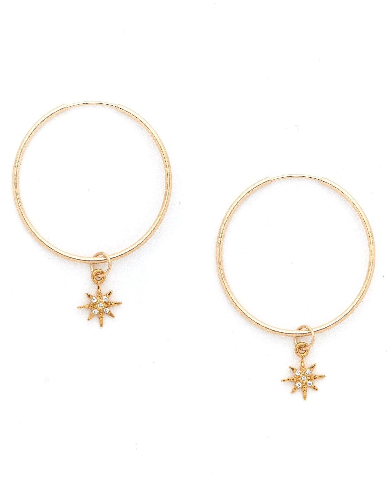 Soleil Hoop Earrings by KOZAKH. 30mm hoop earrings, crafted in 14K Gold Filled, featuring a dangling Cubic Zirconia 6 point star charm.