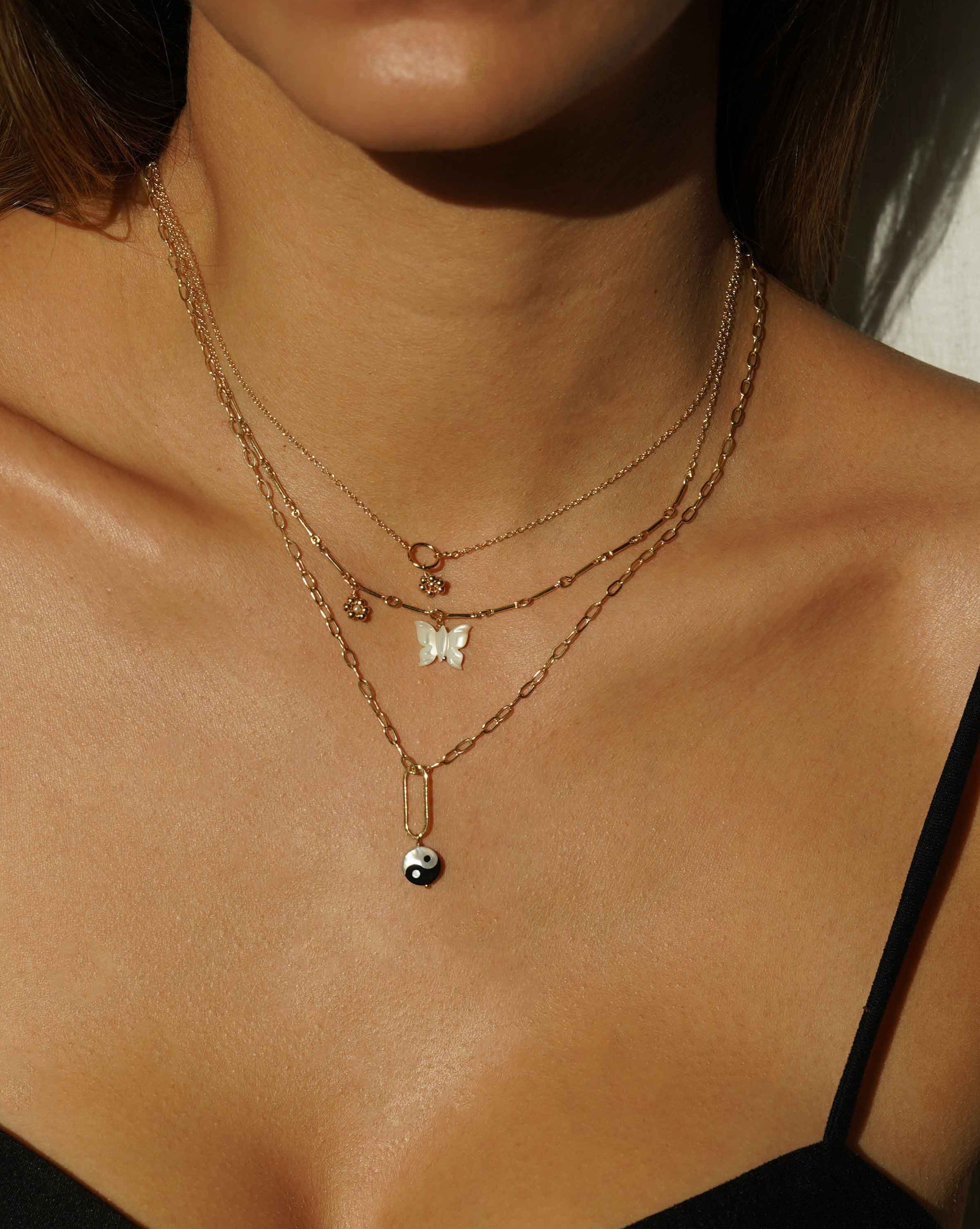 Yin Yang Necklace by KOZAKH. A 16 to 18 inch adjustable length, flat link cable chain necklace, crafted in 14K Gold Filled, featuring a hand carved Mother of pearl Yin Yang charm.