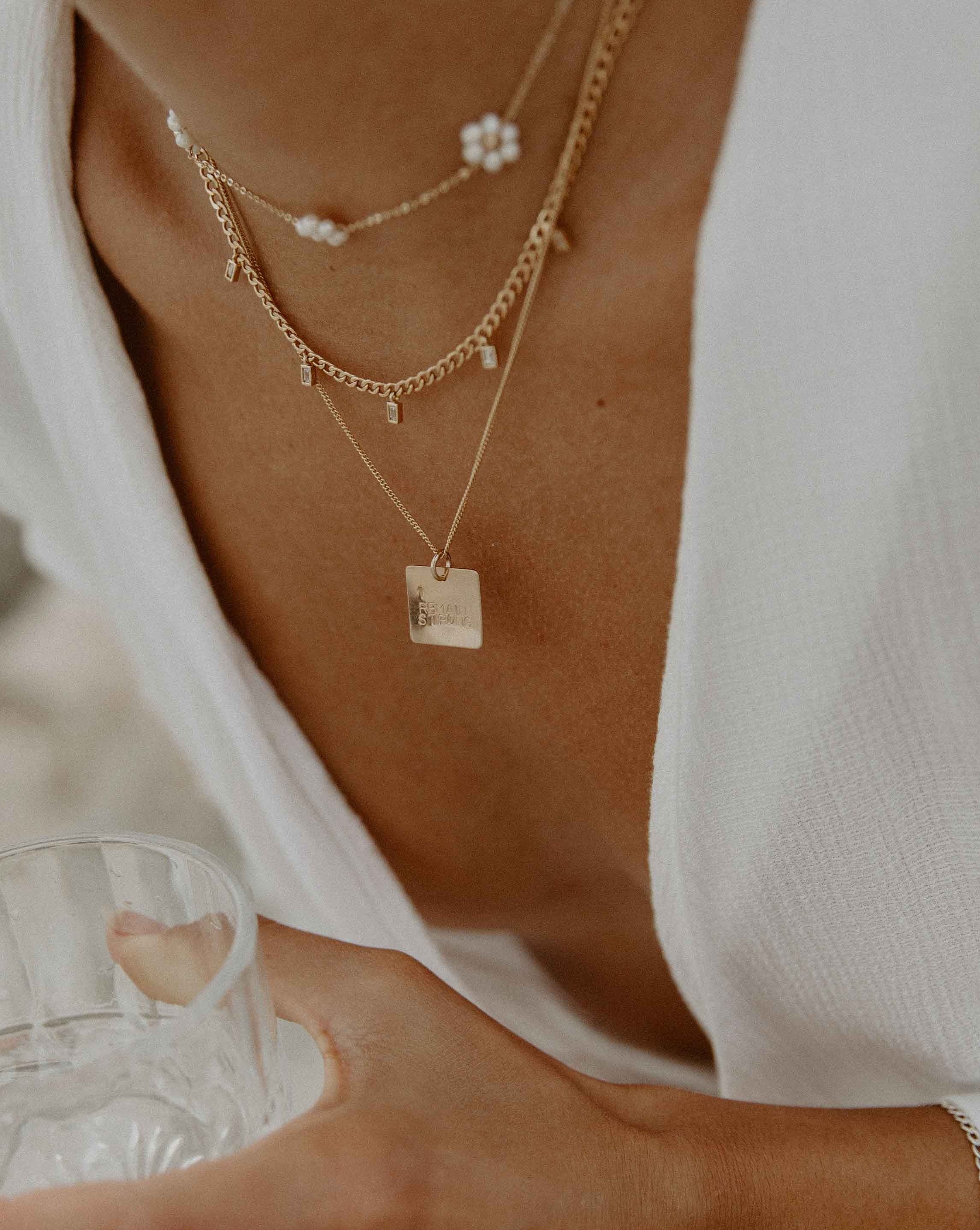 Zola Necklace by KOZAKH. A 16 to 18 inch adjustable length necklace, crafted in 14K Gold Filled, featuring a flat square pendant with engraved customizable quote.