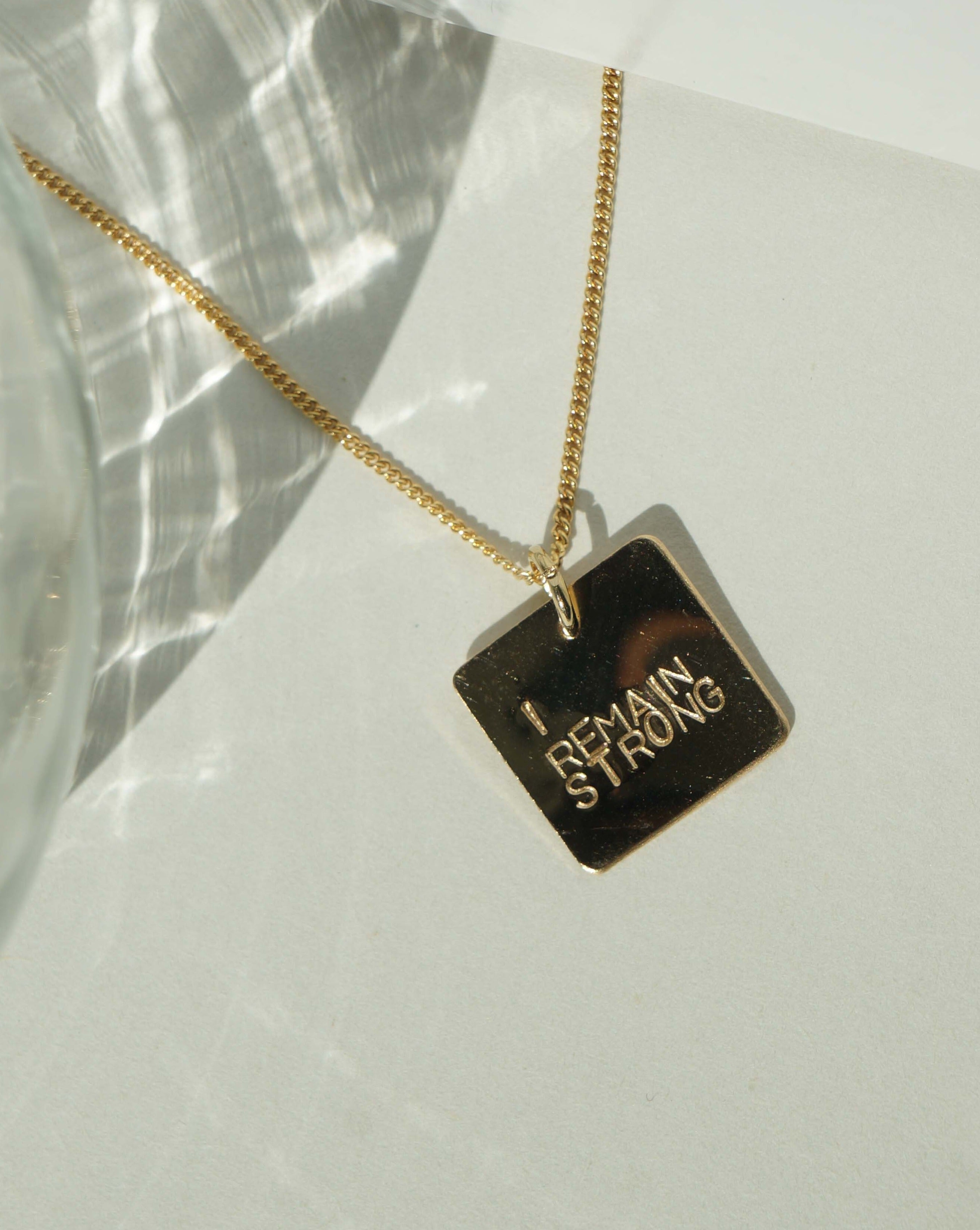 Zola Necklace by KOZAKH. A 16 to 18 inch adjustable length necklace, crafted in 14K Gold Filled, featuring a flat square pendant with engraved customizable quote.